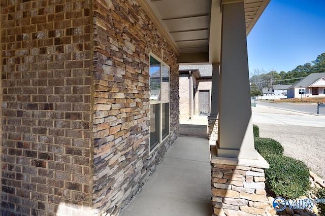 exterior space featuring covered porch and brick siding