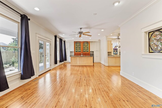 unfurnished living room featuring ornamental molding, light hardwood / wood-style flooring, and ceiling fan