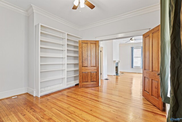 unfurnished bedroom featuring ornamental molding, light wood-type flooring, and ceiling fan