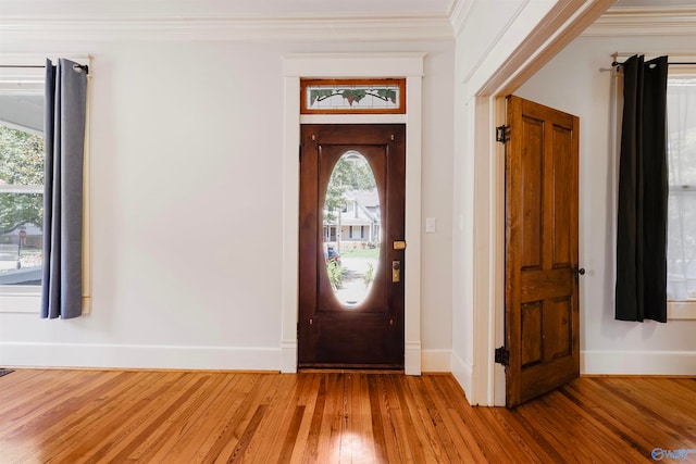 entryway featuring hardwood / wood-style flooring and ornamental molding