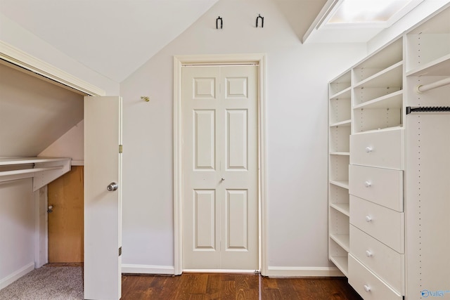 walk in closet with dark hardwood / wood-style flooring and lofted ceiling