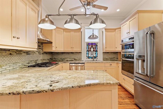 kitchen with backsplash, ceiling fan, appliances with stainless steel finishes, wood-type flooring, and ornamental molding