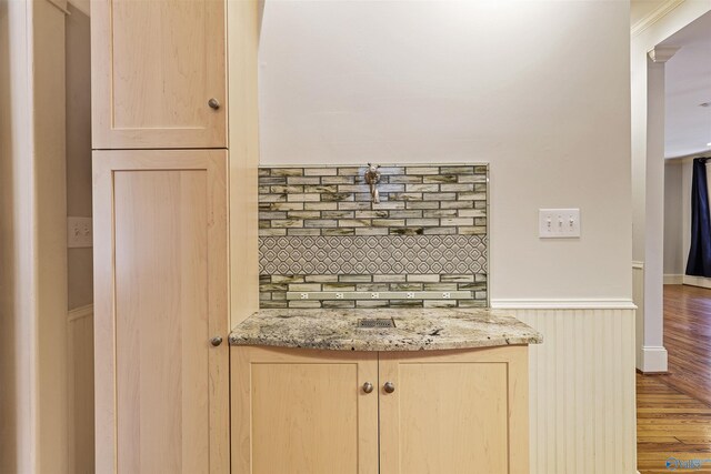 interior space with decorative backsplash and hardwood / wood-style flooring