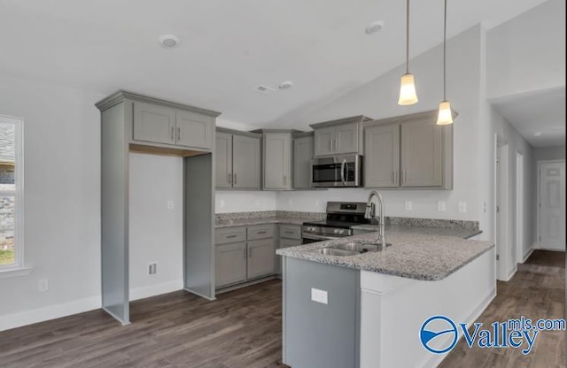 kitchen with light stone countertops, hanging light fixtures, stainless steel appliances, kitchen peninsula, and lofted ceiling