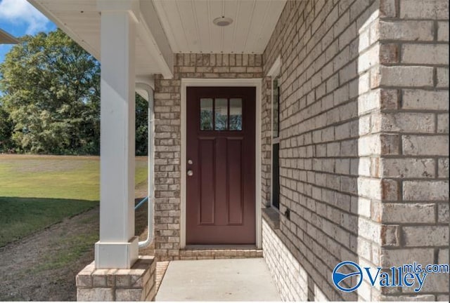 doorway to property with a lawn