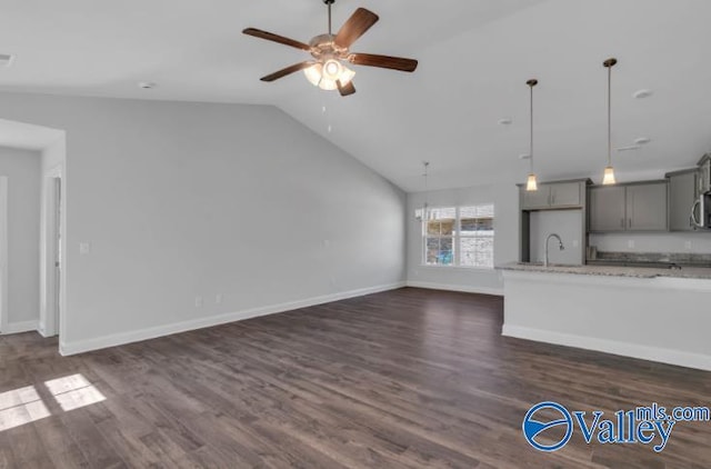 unfurnished living room with dark wood-type flooring, ceiling fan, lofted ceiling, and sink