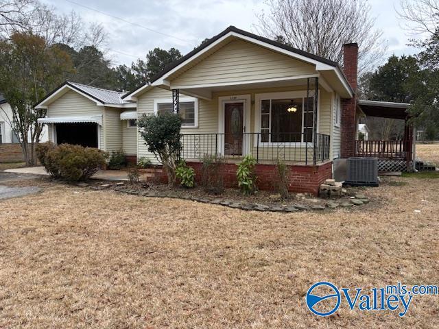 bungalow featuring a front yard, central air condition unit, and covered porch