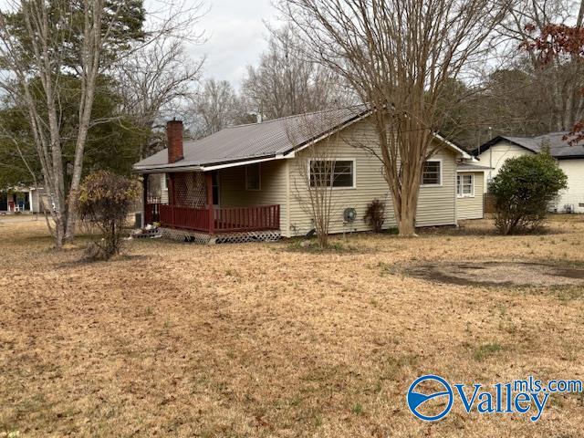 back of property with a yard and a deck