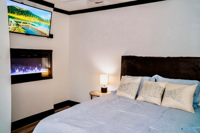 bedroom with crown molding and dark hardwood / wood-style flooring