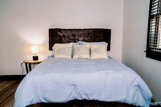 bedroom with dark hardwood / wood-style floors