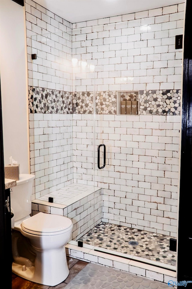 bathroom with toilet, an enclosed shower, and tile patterned flooring