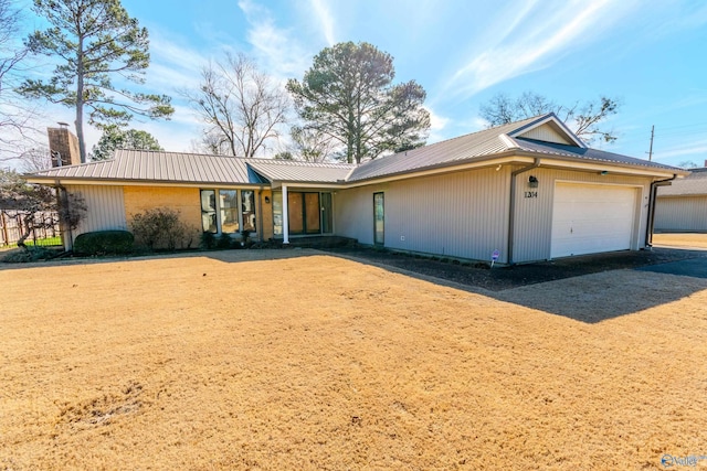 single story home featuring a garage, a chimney, and metal roof