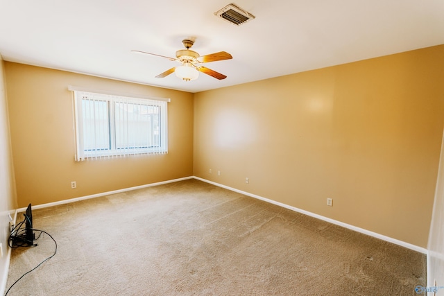 carpeted empty room with visible vents, baseboards, and a ceiling fan