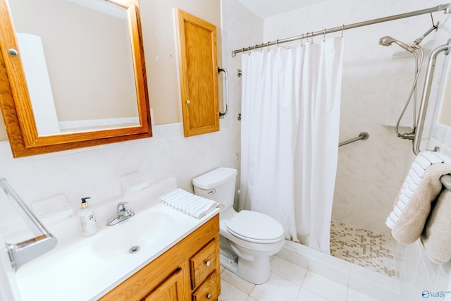 bathroom featuring toilet, tile patterned floors, vanity, a shower stall, and tile walls