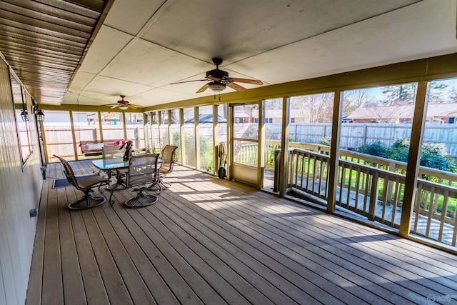 unfurnished sunroom featuring a wealth of natural light and ceiling fan