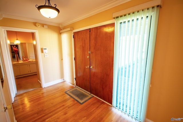 interior space featuring ornamental molding, visible vents, baseboards, and wood finished floors