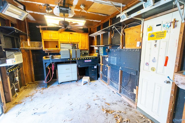 garage featuring a ceiling fan, a workshop area, and a garage door opener