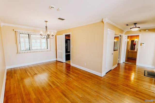 empty room with light wood-type flooring, visible vents, a notable chandelier, and baseboards