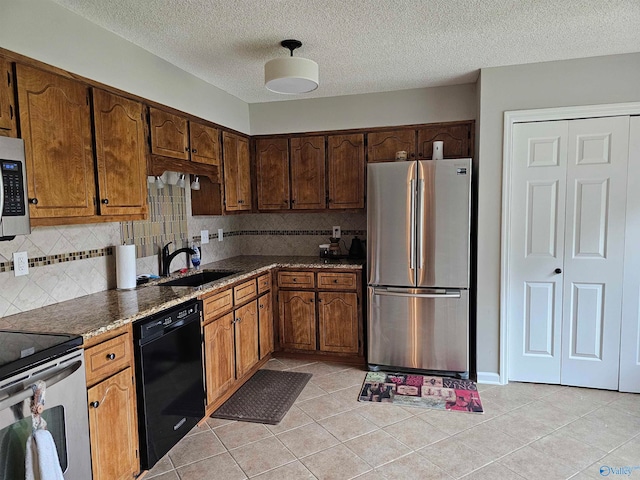 kitchen featuring light tile patterned floors, appliances with stainless steel finishes, sink, and decorative backsplash