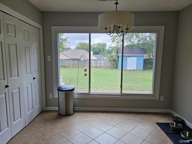 unfurnished dining area featuring a notable chandelier, a healthy amount of sunlight, and light tile patterned floors