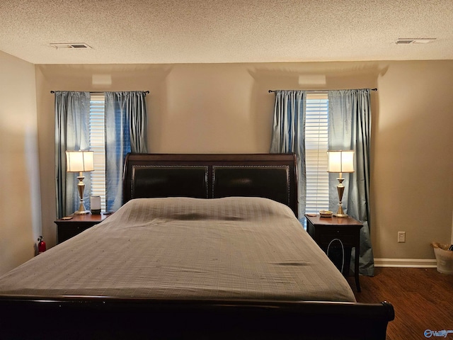 bedroom with hardwood / wood-style floors and a textured ceiling