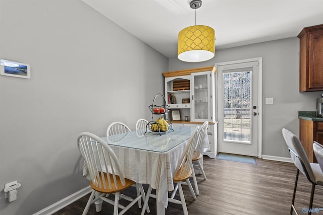 dining room featuring dark wood finished floors and baseboards