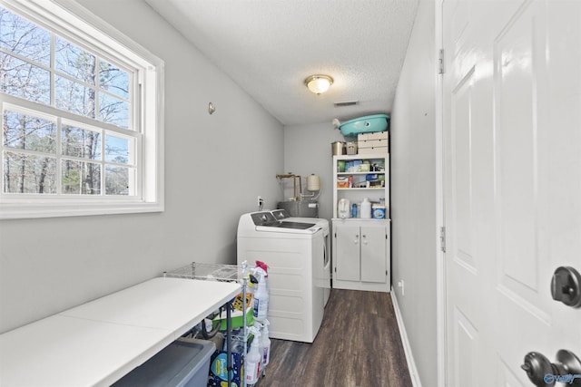 clothes washing area featuring laundry area, visible vents, washer and clothes dryer, dark wood-style flooring, and a textured ceiling