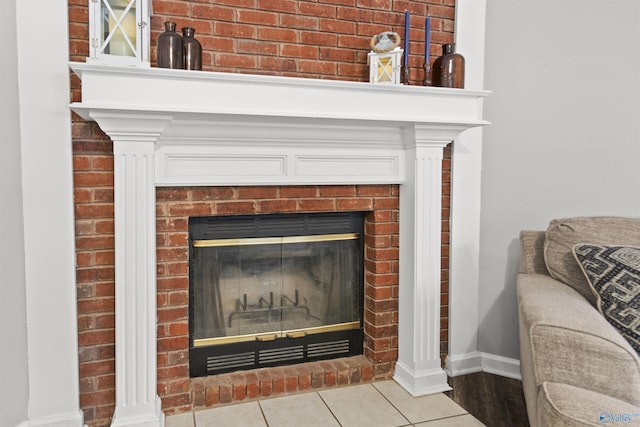 interior details featuring a brick fireplace and baseboards