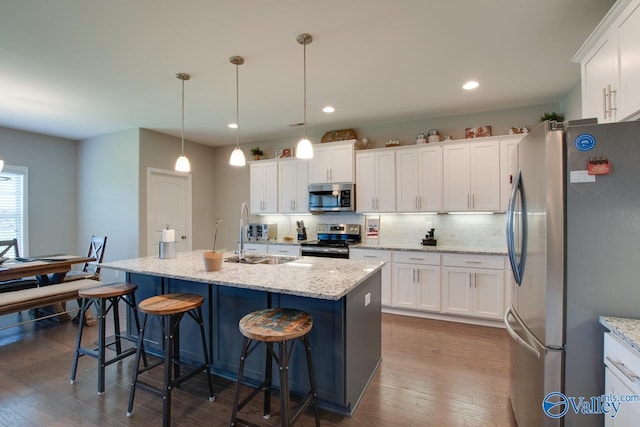 kitchen featuring tasteful backsplash, dark wood finished floors, appliances with stainless steel finishes, white cabinetry, and a sink