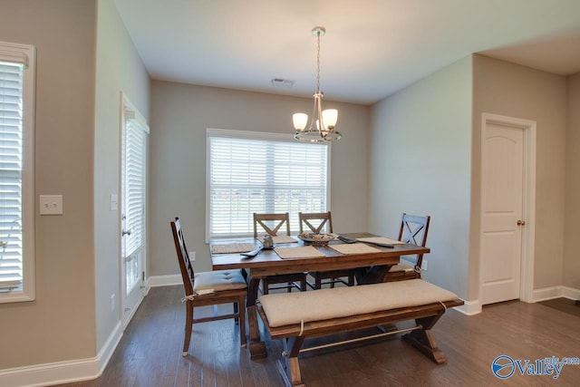 dining room featuring a chandelier, visible vents, dark wood finished floors, and baseboards