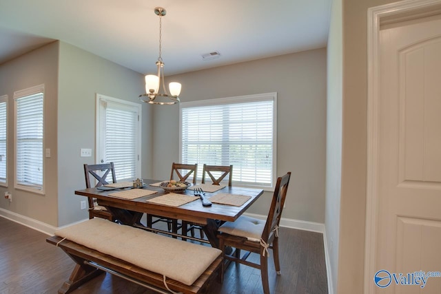 dining space featuring an inviting chandelier, dark wood finished floors, visible vents, and baseboards