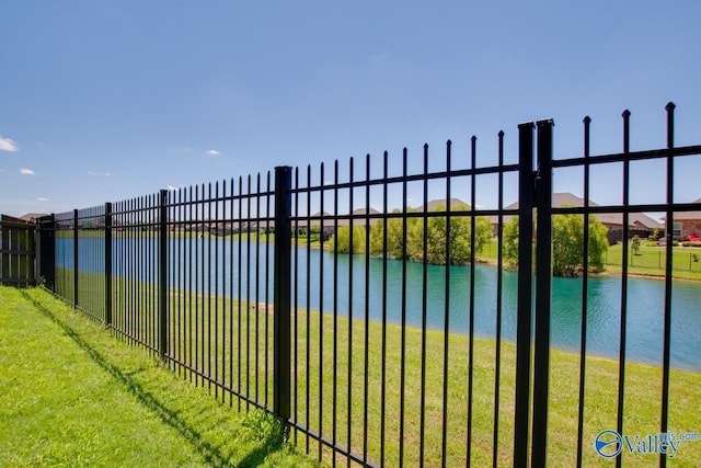 exterior space with a yard, a water view, and fence