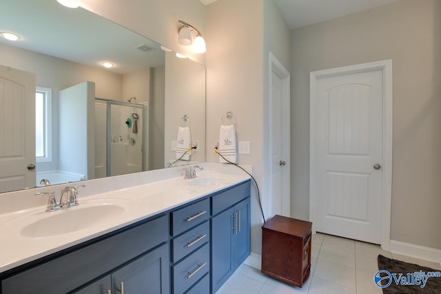 bathroom featuring double vanity, a stall shower, a sink, and tile patterned floors