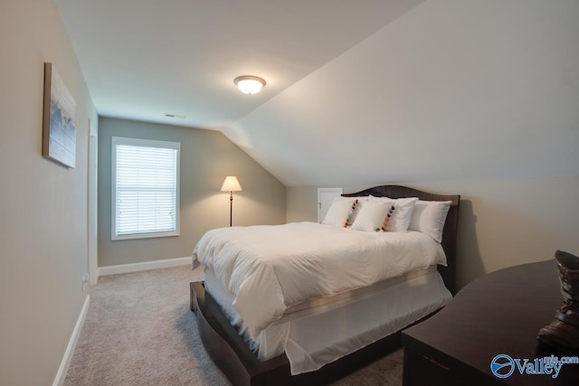 carpeted bedroom featuring lofted ceiling, visible vents, and baseboards