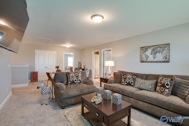 living room featuring light carpet, attic access, and baseboards