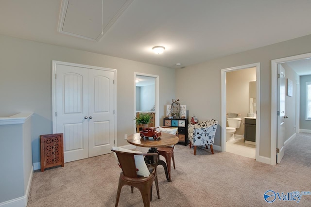 interior space featuring light carpet, attic access, and baseboards