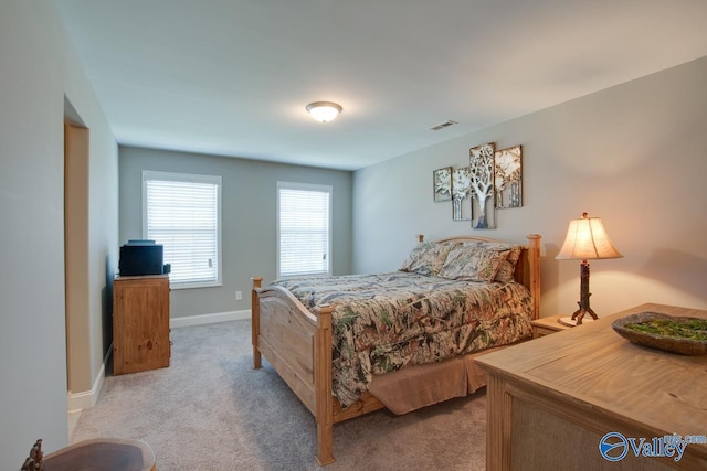 bedroom featuring baseboards, visible vents, and light colored carpet