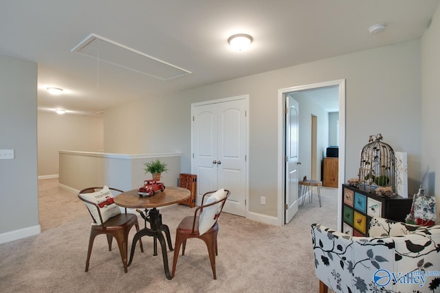 dining space featuring attic access, baseboards, and light colored carpet