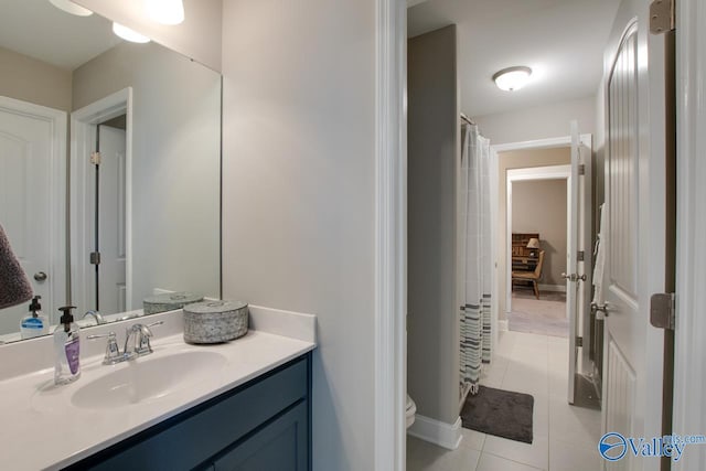 full bathroom featuring curtained shower, toilet, vanity, baseboards, and tile patterned floors