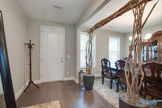 entrance foyer with baseboards, visible vents, and wood finished floors