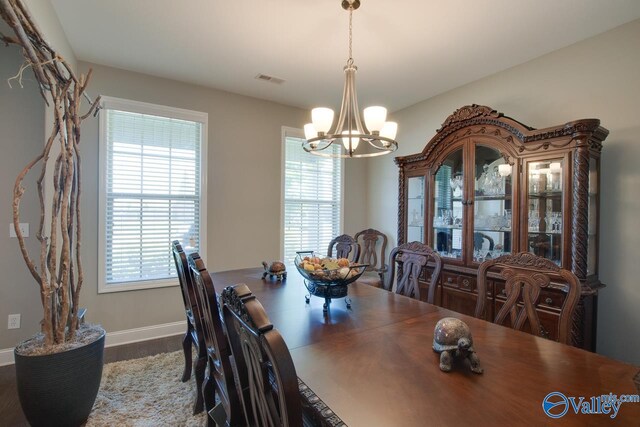 dining room with baseboards, plenty of natural light, and an inviting chandelier