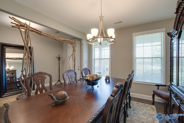 dining space featuring baseboards, visible vents, and a notable chandelier