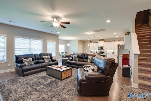 living room with stairs, visible vents, dark wood-type flooring, and recessed lighting