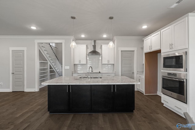 kitchen with appliances with stainless steel finishes, wall chimney exhaust hood, dark hardwood / wood-style floors, and light stone counters