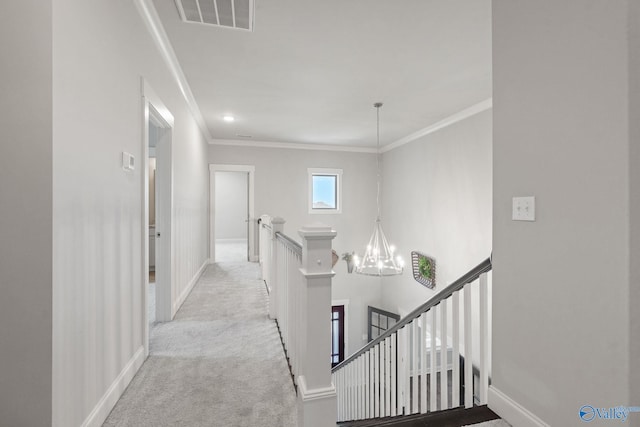 hall featuring an inviting chandelier, ornamental molding, and light carpet