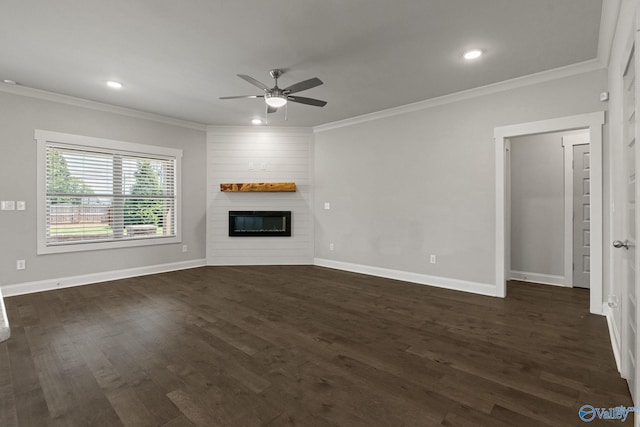 unfurnished living room featuring ceiling fan, a large fireplace, crown molding, and dark hardwood / wood-style floors