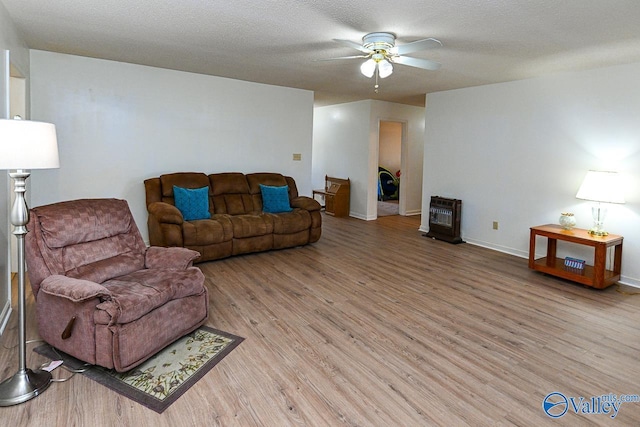living room featuring a textured ceiling, ceiling fan, and light hardwood / wood-style flooring