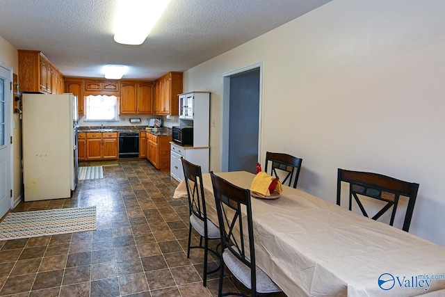 kitchen featuring sink, a textured ceiling, and black appliances