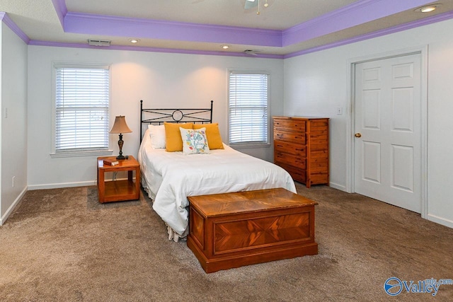 bedroom with crown molding, a tray ceiling, multiple windows, and carpet flooring