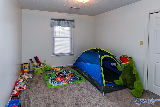 bedroom featuring carpet flooring and a textured ceiling